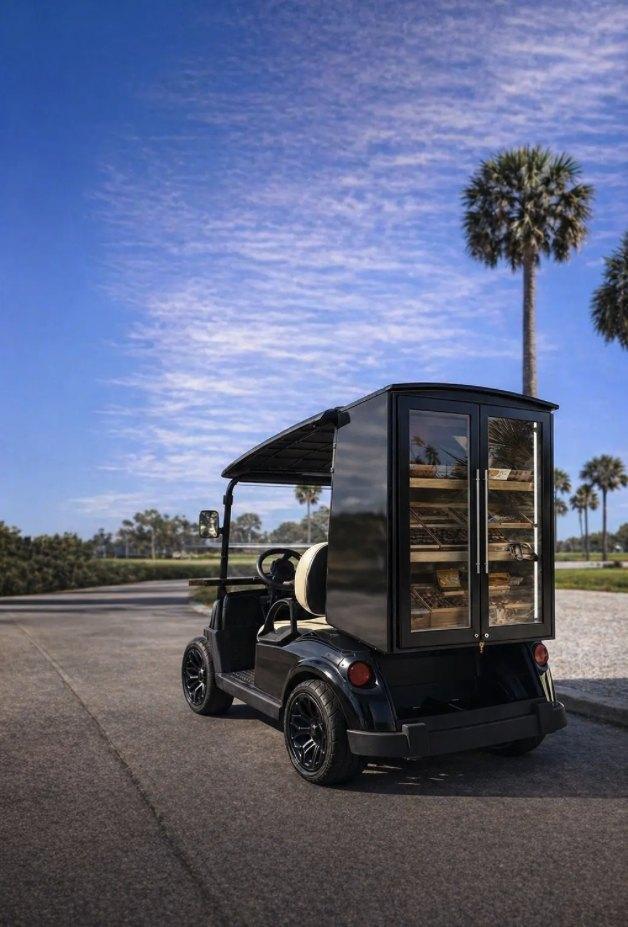 The Signature Humidor on the course, glass doors and shelving under a palm lined sky